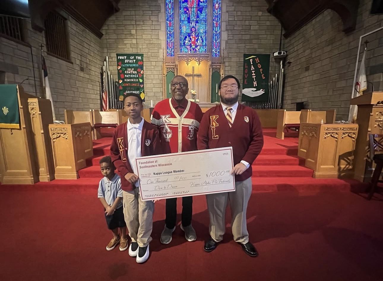 A Kappa League member receiving a $1,000 Dare to Dream scholarship check